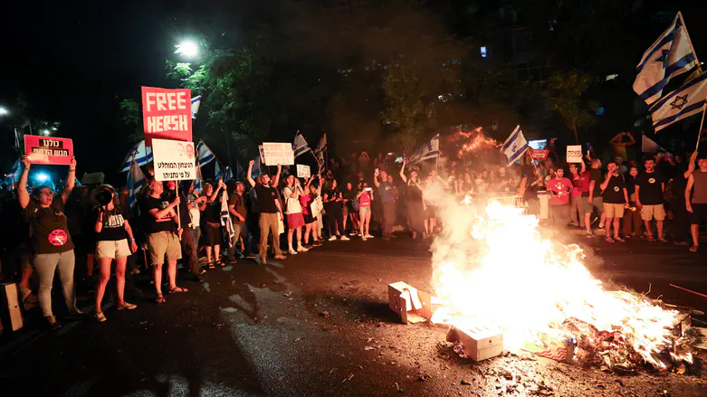 Protesters break through police barriers and light a bonfire