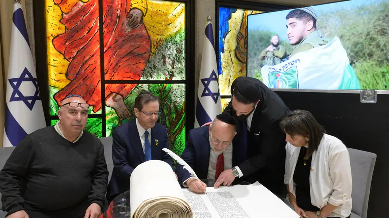 Courtesy of the photographer Herzog writes letter in Torah scroll honoring fallen soldier