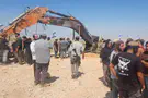 Excavator used by contractor killed in Gaza placed next to grave