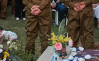 Nine-month-old Lior crawls beside his father's fresh grave