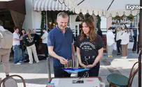 Noa Tishby lights Hanukkah candles with producer Phil Rosenthal