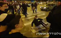Police officer pushes demonstrator towards vehicle