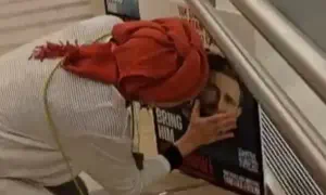 Hostage's mother stops to hug son's picture in airport