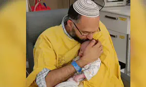 Grandfather circumcises baby Ravid Chaim