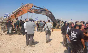 Excavator used by contractor killed in Gaza placed next to grave