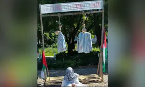 Protestors hang effigies in concentration camp uniforms