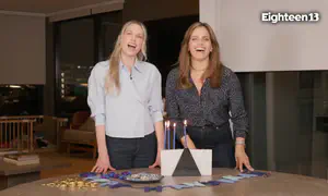 Noa Tishby and Erin Foster light Hanukkah candles