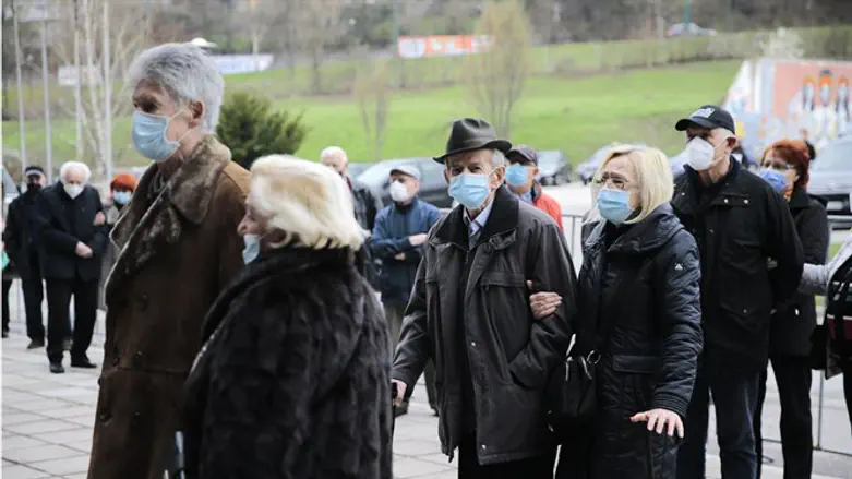 People over 75 years old line up to receive a dose of a COVID-19 vaccine at a sp