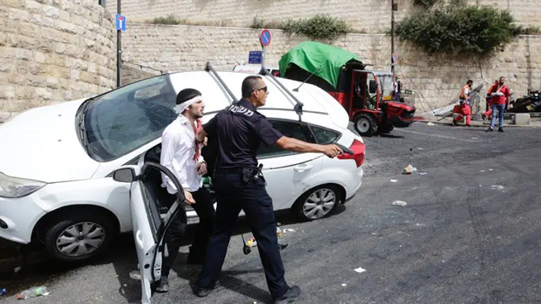 שוטר מגן באקדח שלוף על פצוע לינץ'