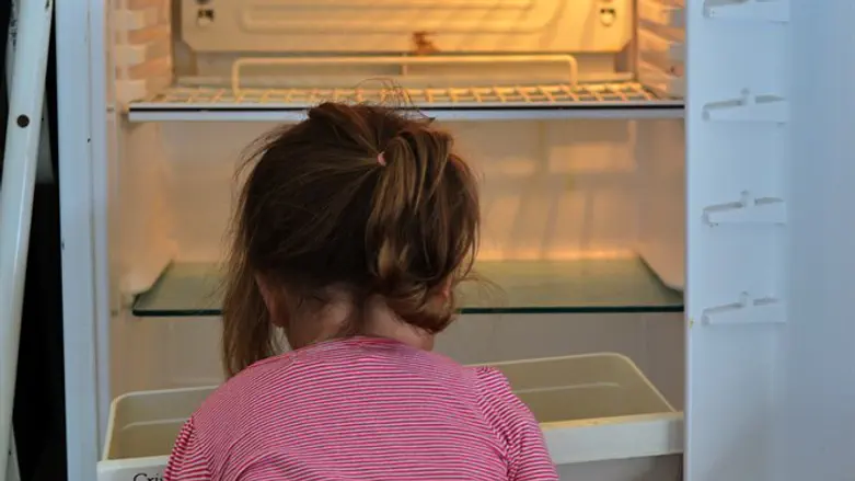 ילד רעב מול מקרר ריק. אילוסטרציה