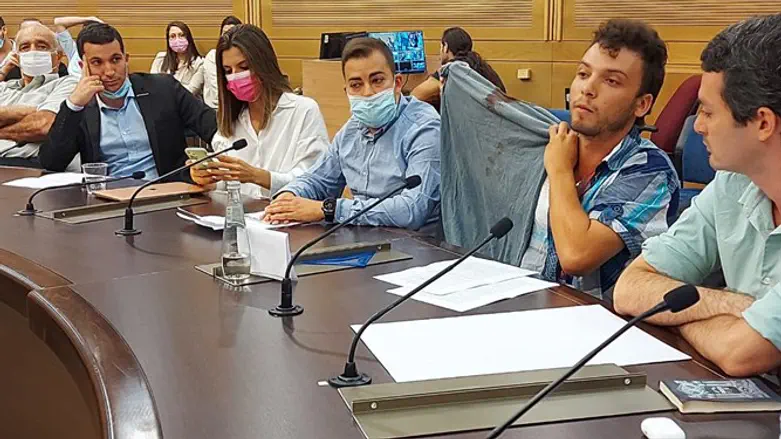 אלעד גביאן מציג את החולצה עם הדם