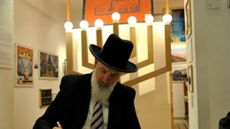 הרב מצגר חותם בספר האורחים