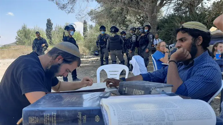 בחורי הישיבה לומדים בחומש על רקע כוחות הפינוי