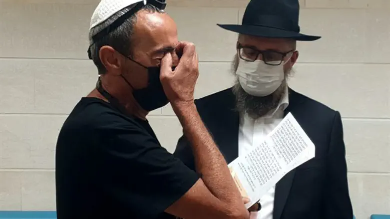 אביו של החייל מניח תפילין עם שליח חב"ד