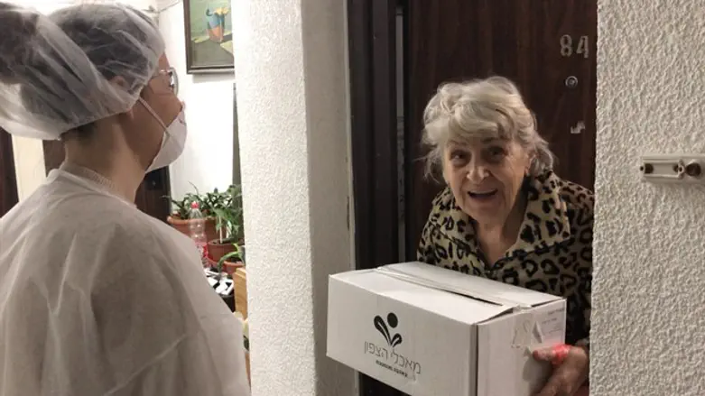 Israel Electric Company employees deliver boxes of fresh produce to Holocaust survivors