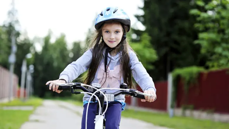 ילדה רוכבת על אופניים. אילוסטרציה