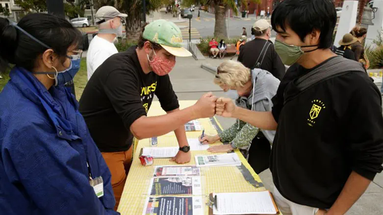 A spokesperson from the Sunrise Movement engages with a protester at the Art Mur
