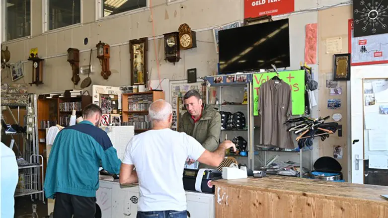 Gideon Italiaander speaks with a customer about a fridge at his shop in Amsterda