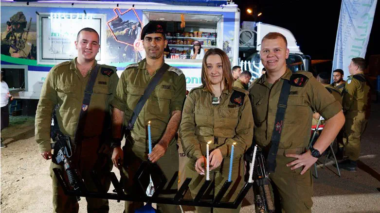 Soldiers from Sufa light candles with IFCJ IDF volunteers