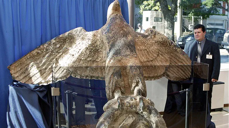 A security guard looks at the bronze eagle recovered from the stern of the Germa
