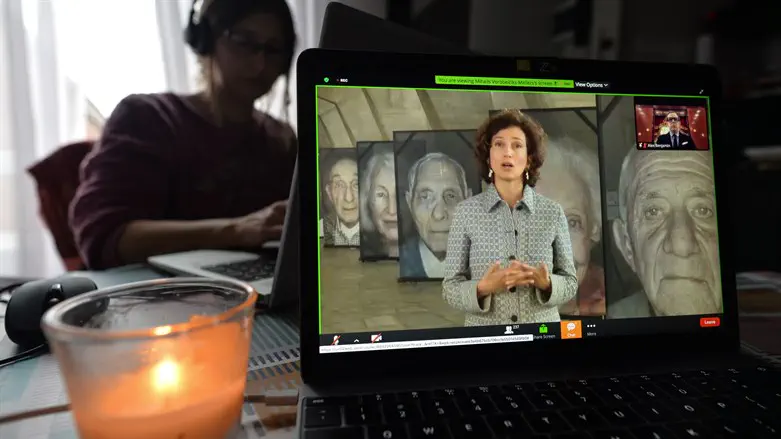 A woman watches Audrey Azoulay, UNESCO Dir.-Gen., speak during online Holocaust event