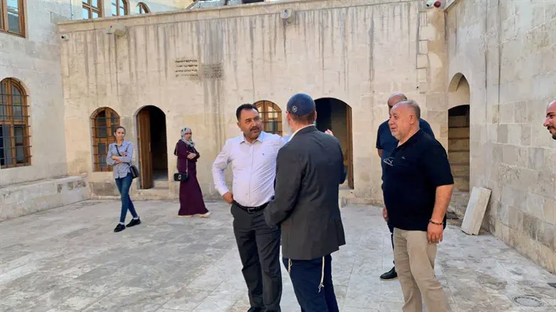 Rabbi Mendy Chitrik, wearing kippah, with locals at the newly-renovated Kilis synagogue