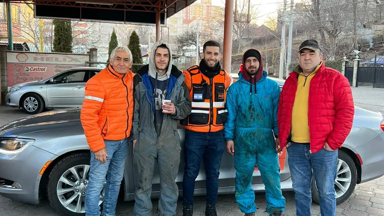 Shay together with another volunteer and the mechanics who helped them.