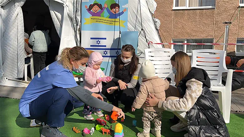 A staffer of the Israeli field hospital plays with children outside the structure.