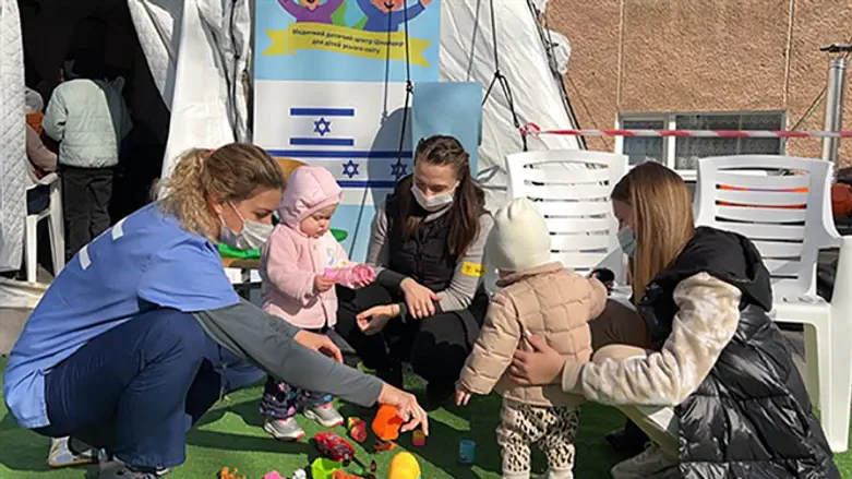 Сотрудница полевого госпиталя "Кохав Меир" играет с детьми