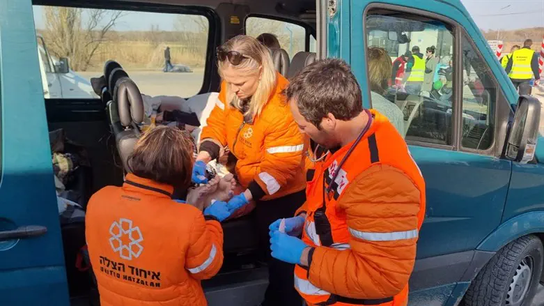 Vicky, Dr. Shaham, & Liat Weiss treat the patient in the van after he crossed the border