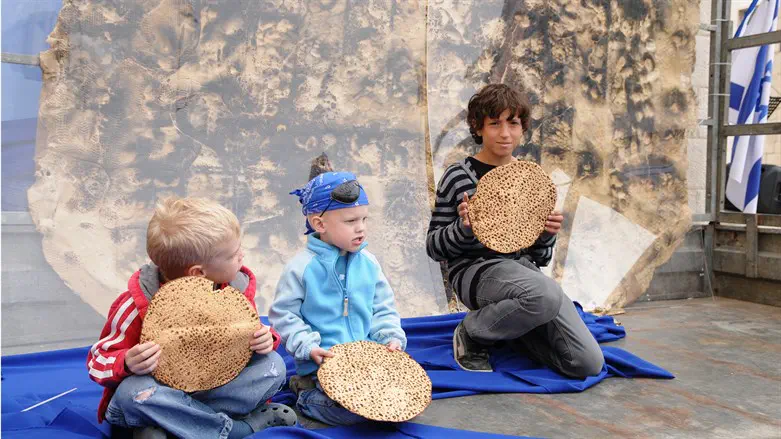 Israeli children eat matza at a Meir Panim center