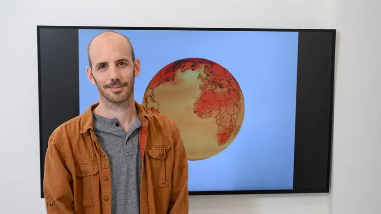 Dr. Chemke with illustration depicting future expected temperature changes to Earth
