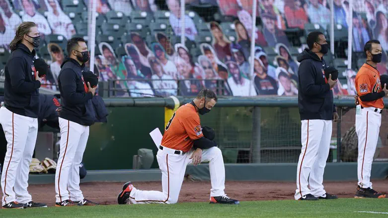 Gabe Kapler kneels during the playing of the National Anthem prior to a game