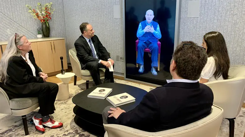 Doug Emhoff, second from left, speaks to an interactive AI video of Pinchas Gutter.