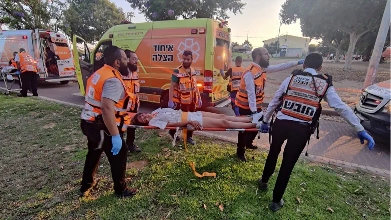 Volunteers carry a patient with simulated injuries to an ambulance during the drill