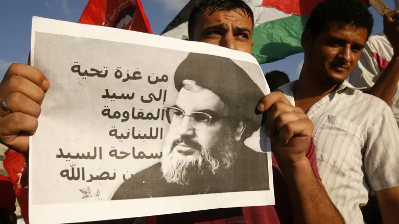 PFLP operative holds picture of Hassan Nasrallah