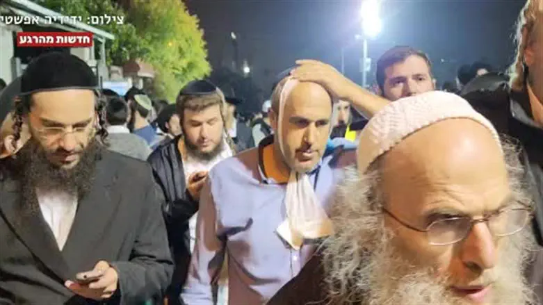 Jerusalem Deputy Mayor Aryeh King is escorted away from Shimon Hatzadik's grave