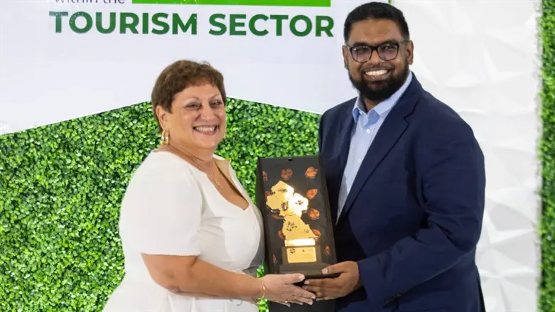 Andrea de Caires is shown with Guyanese President Irfaan Ali