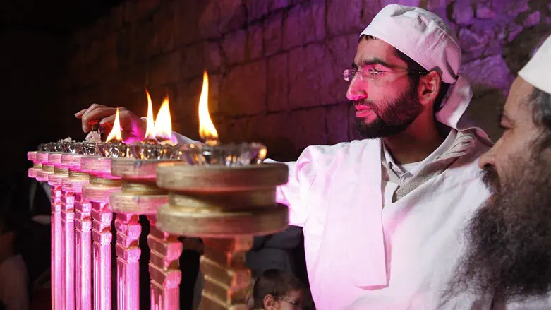 Kohen lights menora in priestly garments