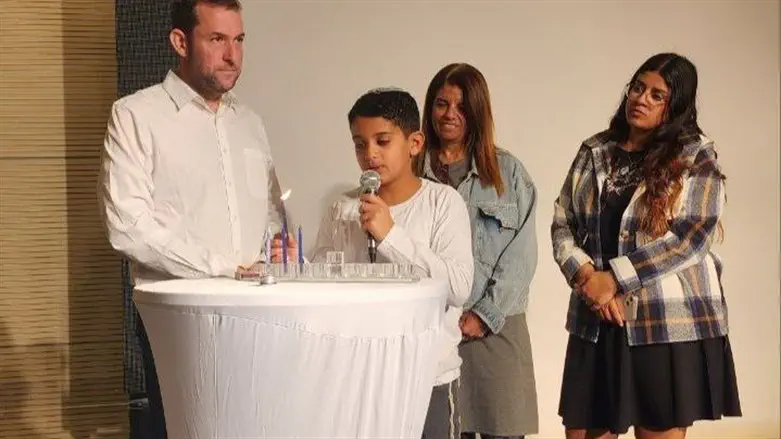 אדיר מדליק את הנר עם אמו ואחותו