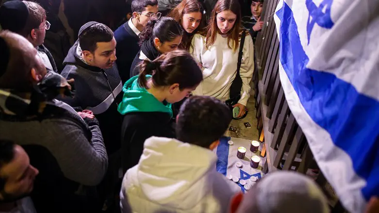 People light candles in memory of the seven people murdered in Jerusalem