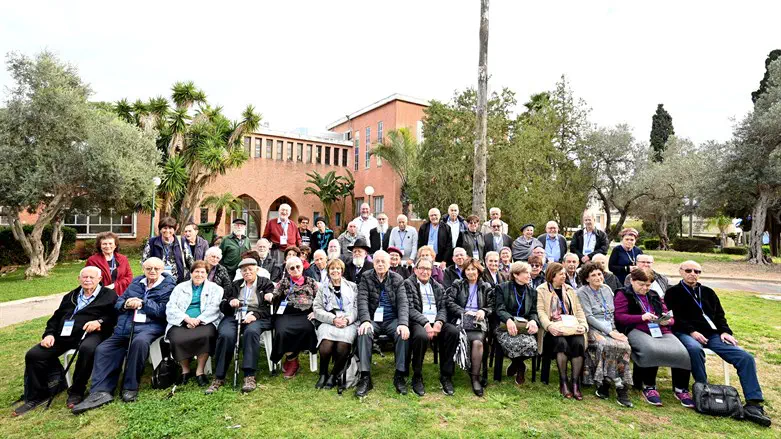 תמונה קבוצתית של חברי שבט איתנים על רקע הישיבה בכפר הרא"ה