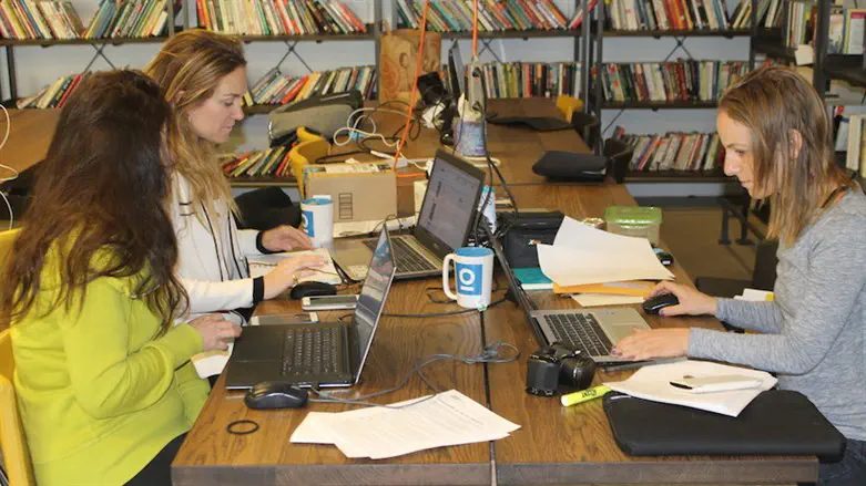 Women at work in a communal workspace .