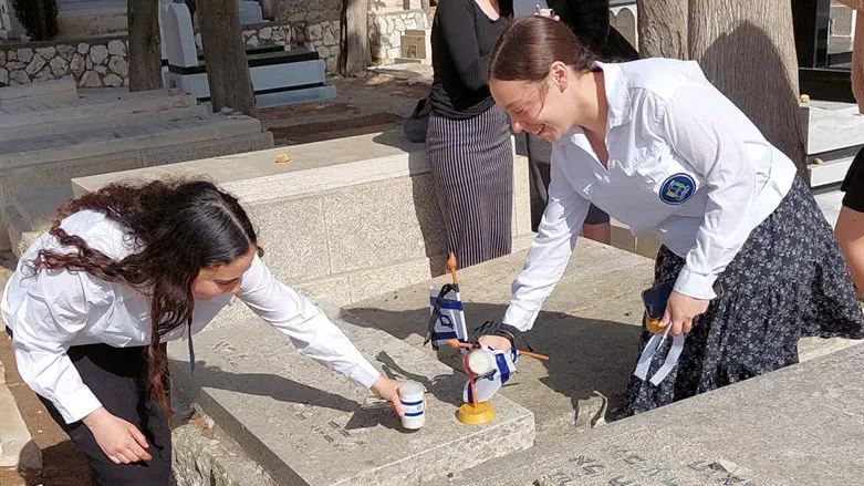חניכות בני עקיבא מניחות נר ודגל על קבר חלל