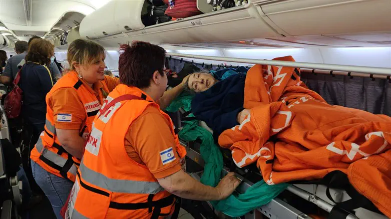 The elderly woman with United Hatzalah volunteers on the plane to Israel