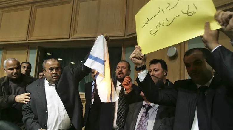 Khalil Atiyah (2nd L) holds a burning Israeli flag in the Jordanian Parliament