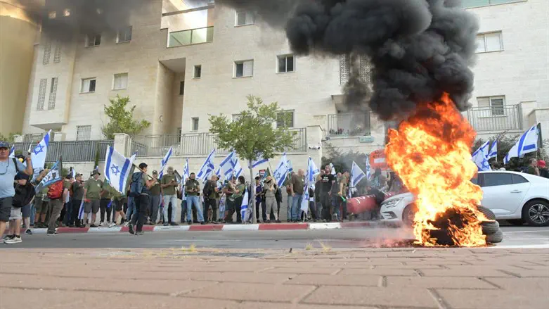 Protesters burn tires outside the home of Justice Minister Yariv Levin in Modiin