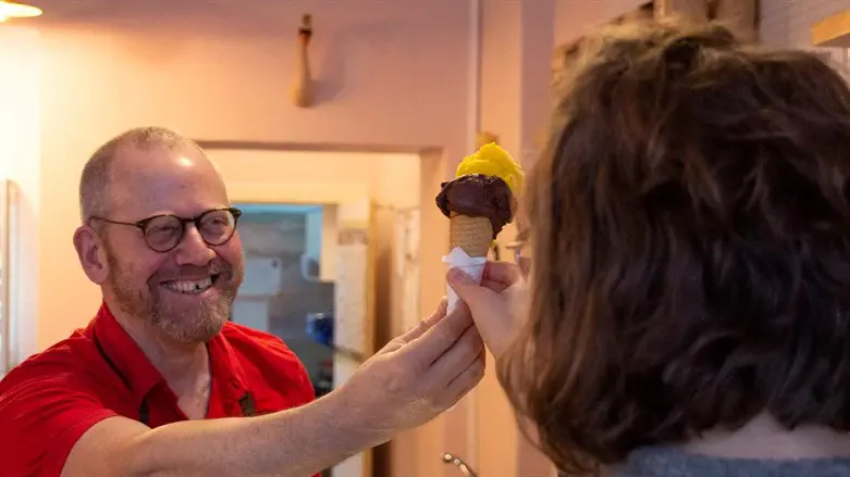 Avi Berg helps a customer in his Cafe Dodo in Berlin.