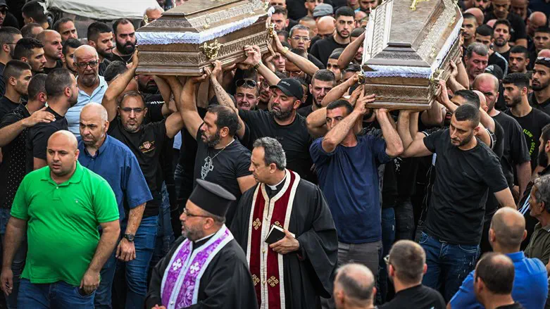 Mourners carry the coffins of two of the five men who were murdered in Nazareth