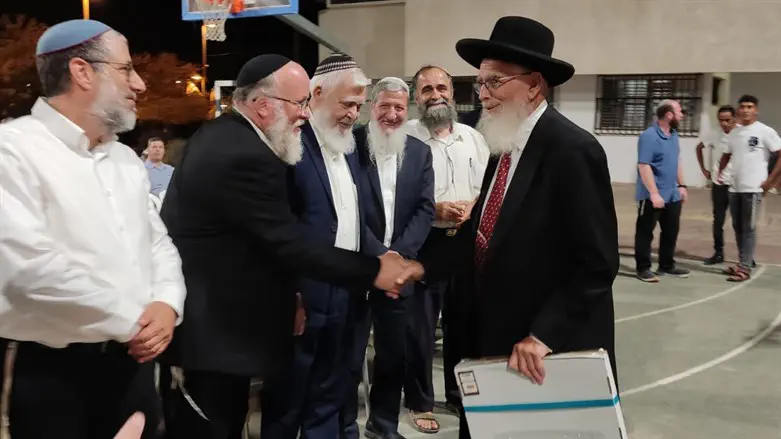 הרב אקשטיין (במרכז) לוחץ ידיים לרב אריאל